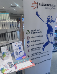 Auf dem Foto ist unser Stand mit einem Rollup und Flyern in der Filiale von DM zu sehen